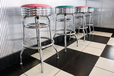 Empty chairs and table on tiled floor