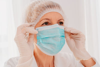 Female doctor wearing mask with face shield looking away