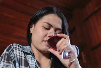 Portrait of young woman drinking glass