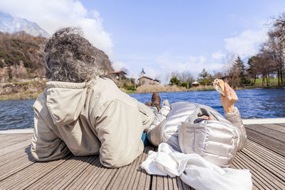 Couple lying on pier over lake