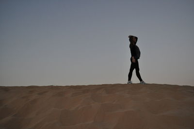 Full length of woman standing on landscape against clear sky