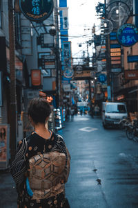 Rear view of man standing on city street