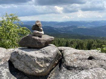 Stack of rocks on mountain against sky
