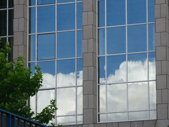 Low angle view of glass building against sky