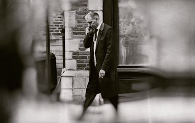 Reflection of man on mobile phone while walking on mirror