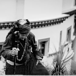 Midsection of woman holding umbrella against building