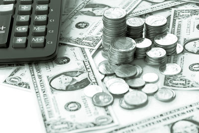 High angle view of coins with calculator on table