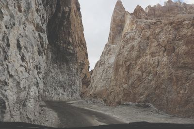 Road amidst rock formation against sky