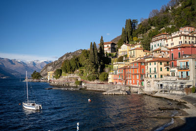 Scenic view of sea and mountains against clear blue sky