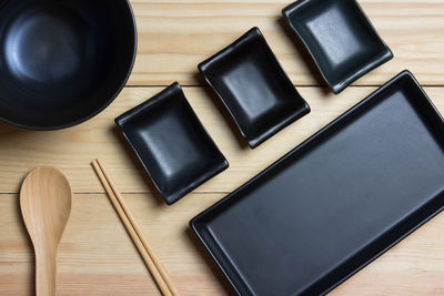 Black plates and black bowl are empty.