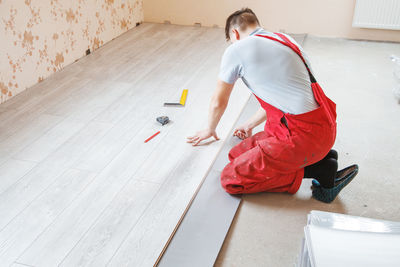 Side view of carpenter working on floor at home