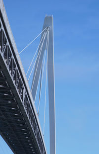 Low angle view of suspension bridge against blue sky