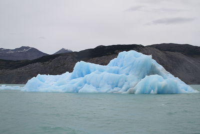 Ice formation in river at ohiggins glacier against mountains