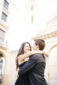 Couple embracing against historic building