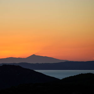 Scenic view of silhouette mountains against romantic sky at sunset