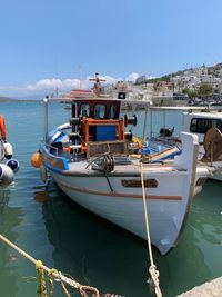 Sailboats moored on sea against sky
