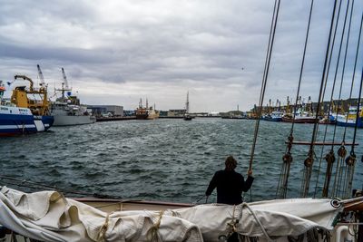 Rear view of people in sea against sky