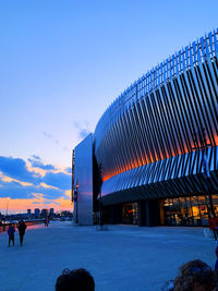 People on building against blue sky at sunset