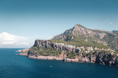 Scenic view of sea and mountains against blue sky