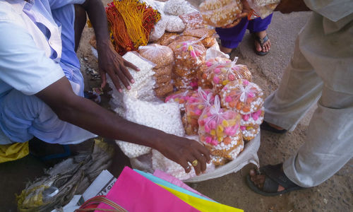 Low section of man selling sweets and flowers in puri
