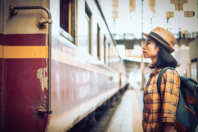 Full length of woman standing by train at railroad station