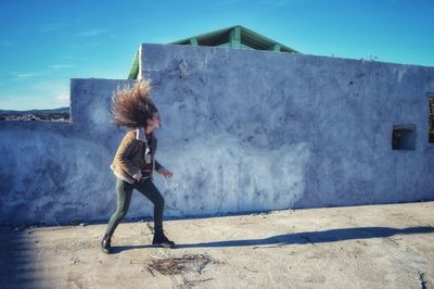 Side view of woman standing against sky