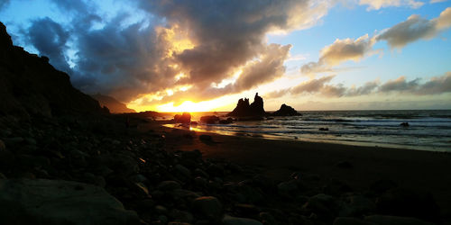 Scenic view of beach against sky during sunset