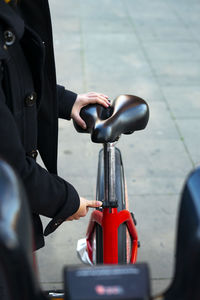 Woman adjusting the saddle of the bike.