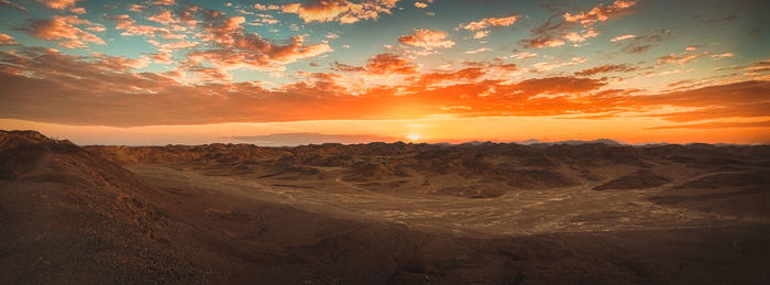 Scenic view of desert against sky during sunset