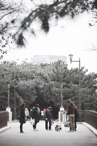 Rear view of people walking on street in city