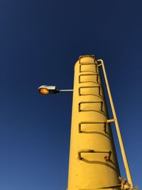 Low angle view of illuminated street light against blue sky