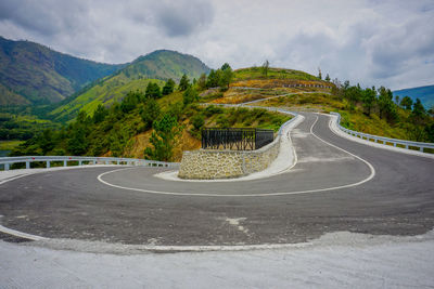 Road leading towards mountains against sky