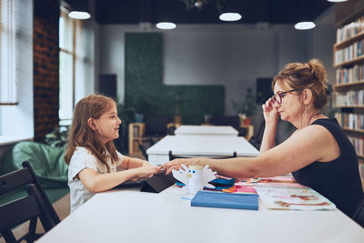 Teacher assisting schoolgirl during art class. child doing homework. primary school. learn and fun