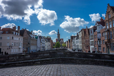 Buildings in city against cloudy sky