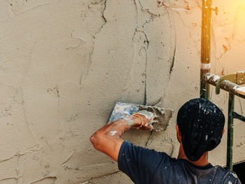 Man working against wall