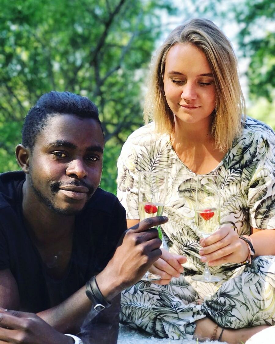 HAPPY YOUNG COUPLE SITTING ON A WOMAN