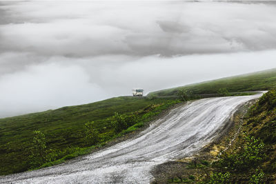 Scenic view of road amidst land against sky