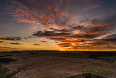 Scenic view of field against orange sky