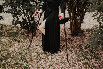 Woman standing by flowering tree on field