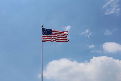 Low angle view of flag against blue sky