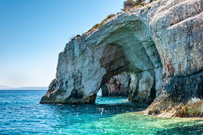 Scenic view of rock formation in sea against sky