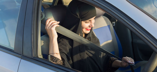 Islamic woman driver owner of car at open door. traditional islamic clothing