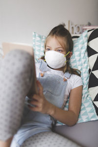 Girl using digital tablet on bed at home