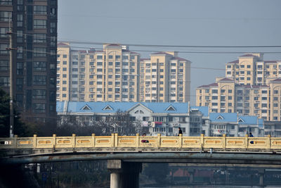 Train on bridge against buildings in city