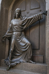 Statue of woman in front of building