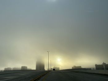 Road by street against sky in city