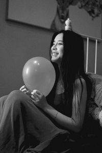 Portrait of a smiling young woman holding balloons