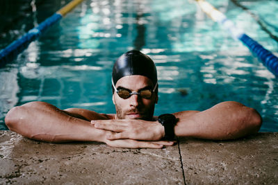 Portrait of shirtless man swimming in pool