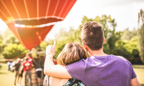 Rear view of couple kissing against sky