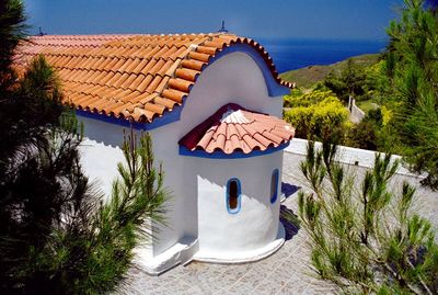 High angle view of house and trees against blue sky